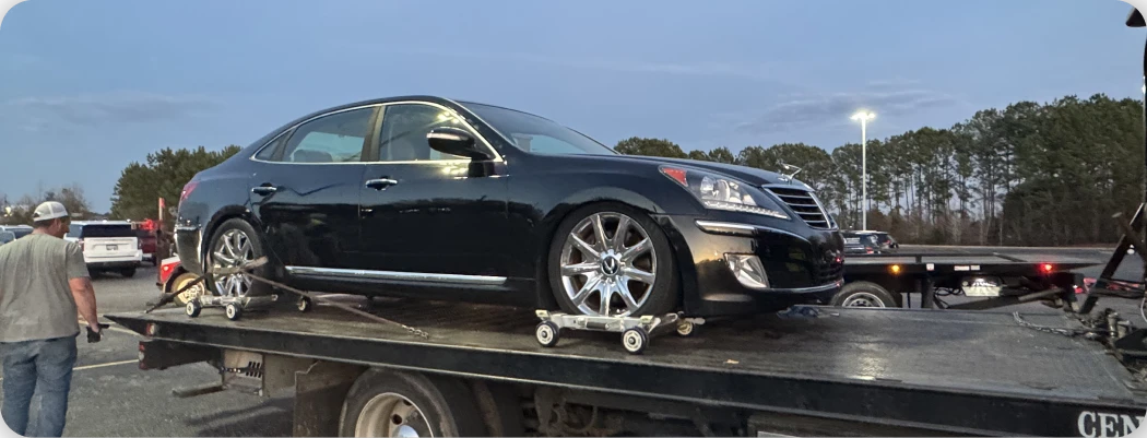 Black car being towed on truck