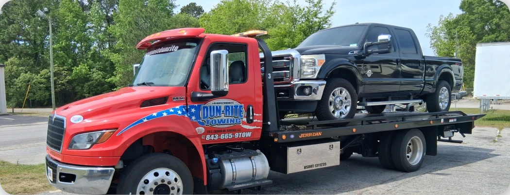 Red tow truck with black pickup