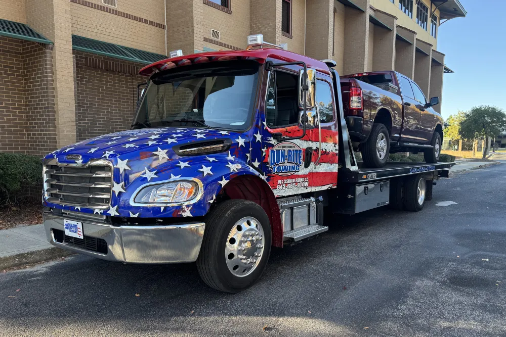Tow truck with vehicle on trailer
